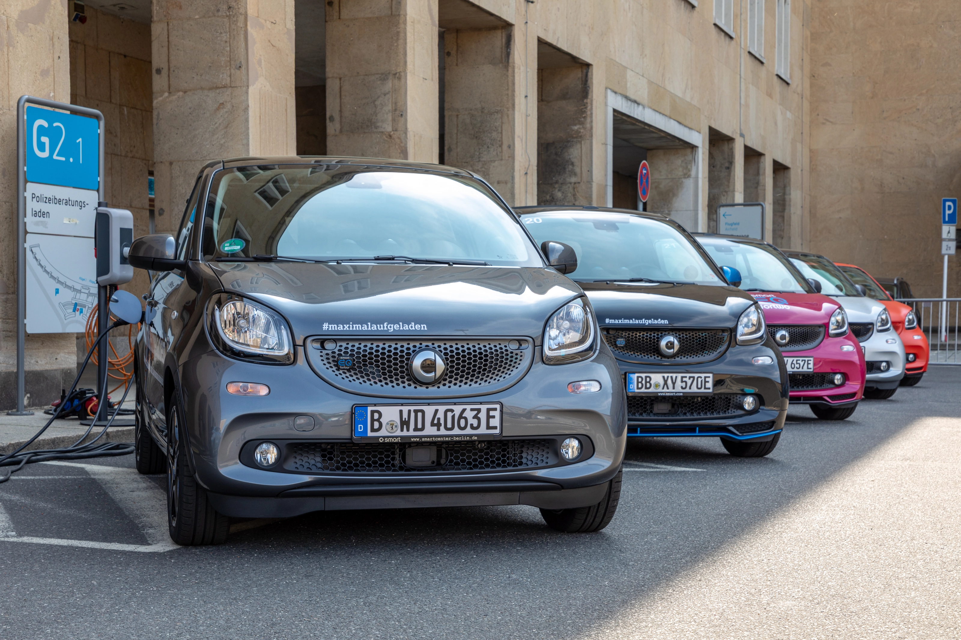 Reihe von Smart EQ Forfour an Ladesäulen vor dem ehemaligen Flughafen Berlin-Tempelhof, vorne ein angeschlossenes Fahrzeug mit dem E-Kennzeichen B-WD 4063E