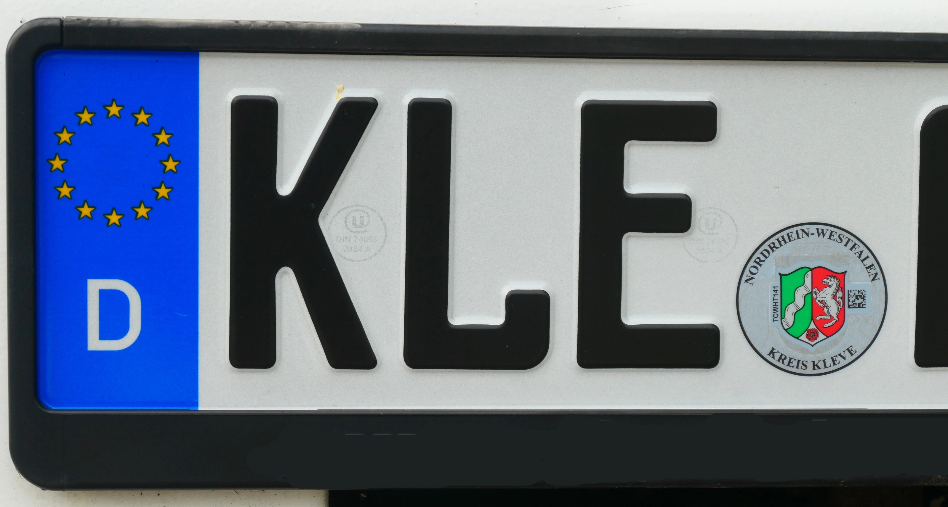 Nahaufnahme eines deutschen Kfz-Kennzeichens: blaues EU-Band mit Sternenkranz und dem Buchstaben D, daneben das Unterscheidungszeichen KLE und die runde Stempelplakette des Kreises Kleve