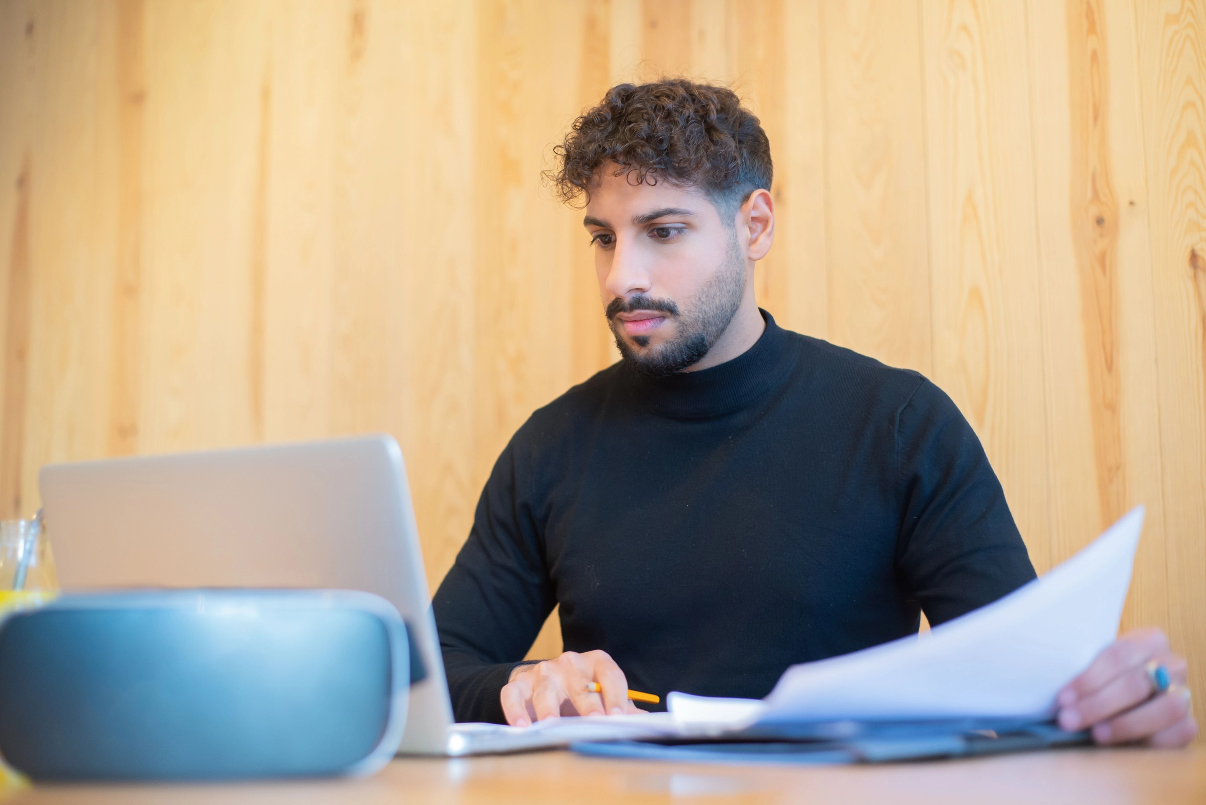 Mitarbeiter am Schreibtisch mit Laptop und Unterlagen